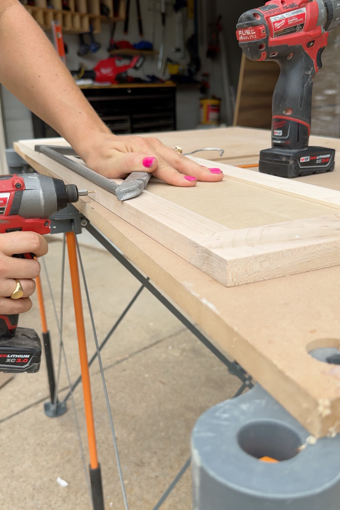 Painting unfinished drawer faces with a sprayer.